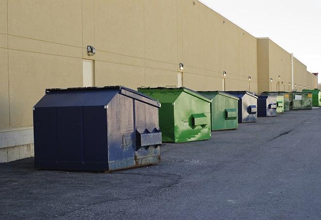 a row of yellow and blue dumpsters at a construction site in Crown Point, NY